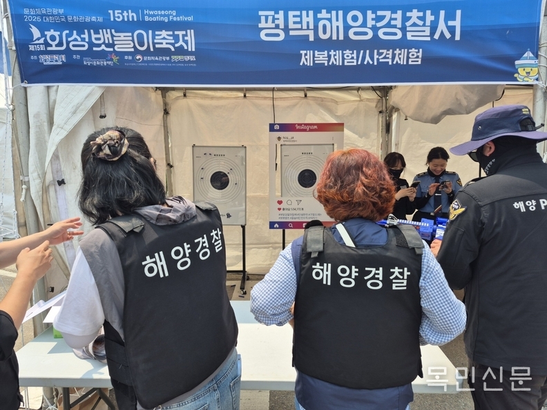 제15회 화성 뱃놀이 축제 첫날 시민들이 해양경찰 제복을 입고 사격체험을 하고 있다. <사진=민경호 기자>